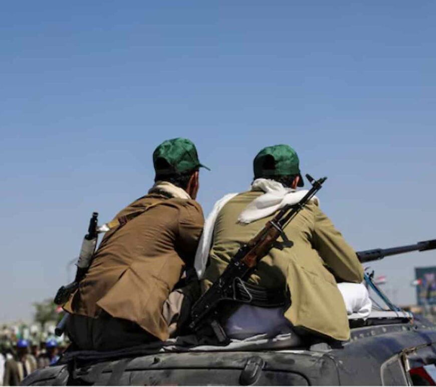 Houthi-mobilized fighters ride atop a car in Sanaa, Yemen