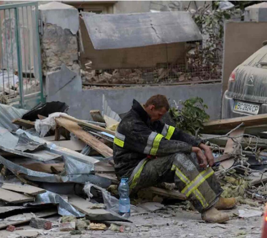 A rescuer rests at the site of a Russian drone and missile strike on residential buildings, amid Russia's attack on Ukraine, in Lviv, Ukraine