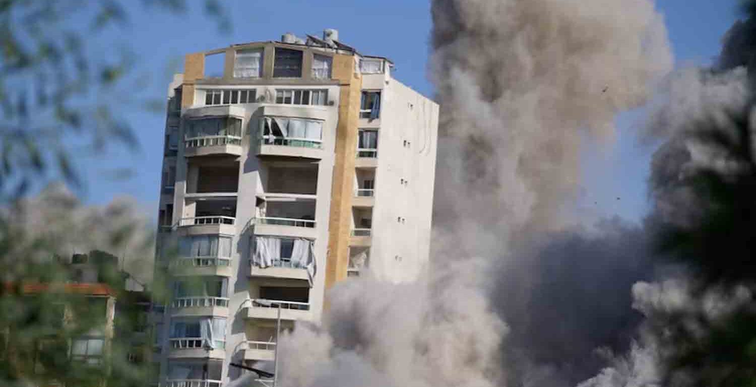 Smoke rises as a building collapses following a missile strike, amid ongoing hostilities between Hezbollah and Israeli forces, in Beirut's southern suburbs, Lebanon