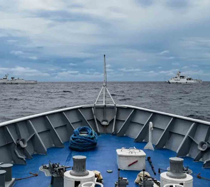 Two Chinese coastguard ships seen from the bow of a Philippine vessel at Sabina Shoal