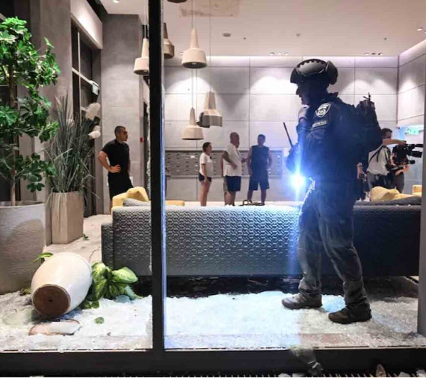 An Israeli police officer inspects the damage to a residential building caused by a rocket fired towards Israel from Lebanon, amid cross-border hostilities between Hezbollah and Israel, in Haifa, Israel.