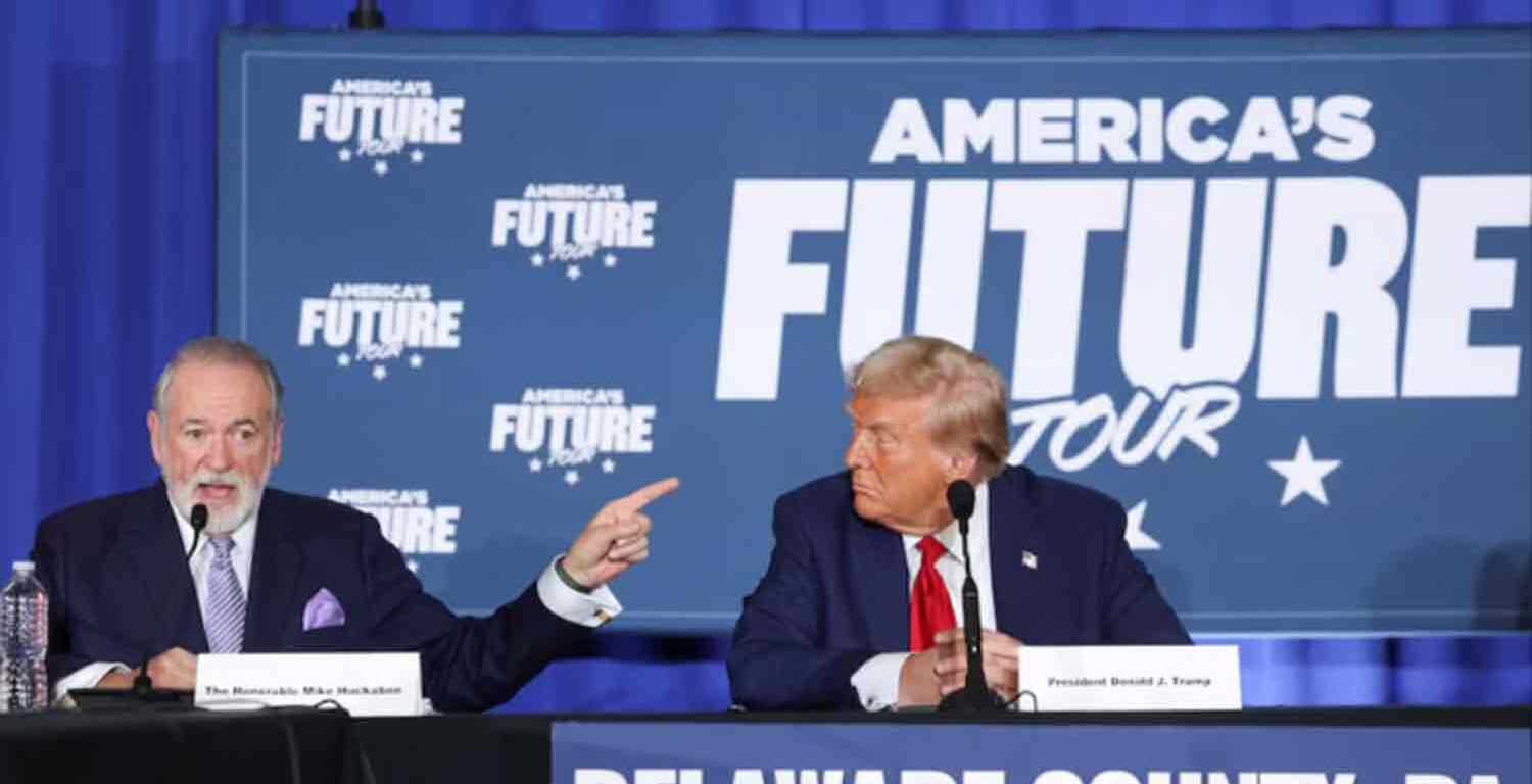 Mike Huckabee speaks as Republican presidential nominee and former U.S. President Donald Trump looks at him during a campaign event at the Drexelbrook Catering and Event Center, in Drexel Hill, Pennsylvania, U.S.