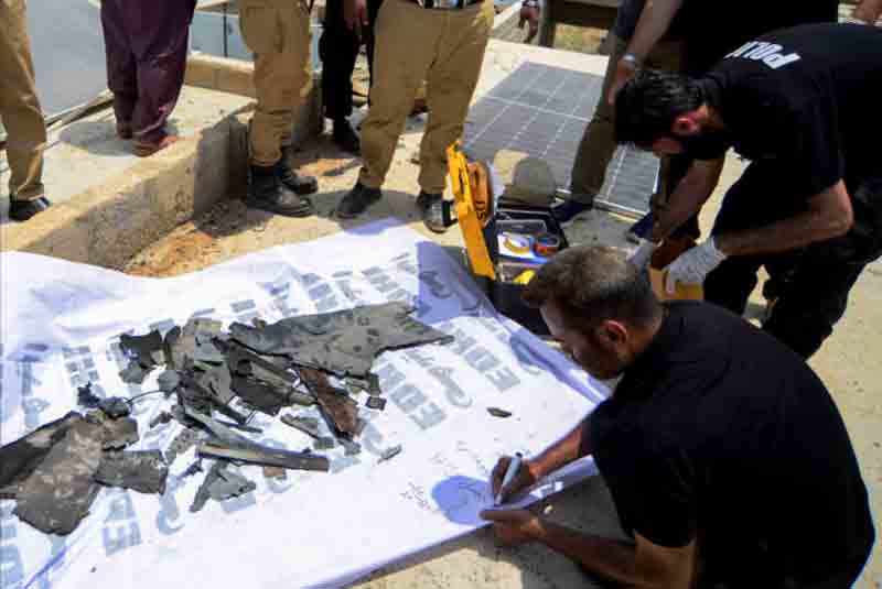 indian-drone-debris-near-karachi A member of the Crime Scene Unit (CSU), inspects the fregments, of what they say is a drone, after it was brought down on the outskirts of Karachi, Pakistan۔